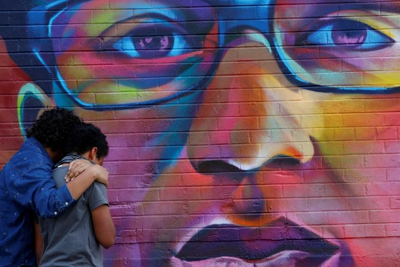 Noah and his older sister visit a mural of Elijah McClain, a 23-year-old Black man who died after an encounter with police officers, ahead of the one year anniversary of his death in Denver, Colorado. REUTERS/Kevin Mohatt  